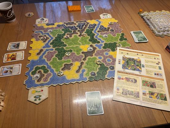 Die empfohlene Startaufstellung des Spiels Kingdom Builder auf einem Holztisch. 