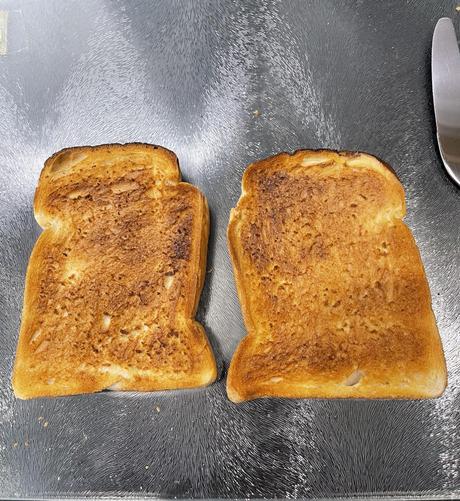 Two slices of Brennan’s White Pan Loaf uniformly toasted to be a deep golden brown all over. 