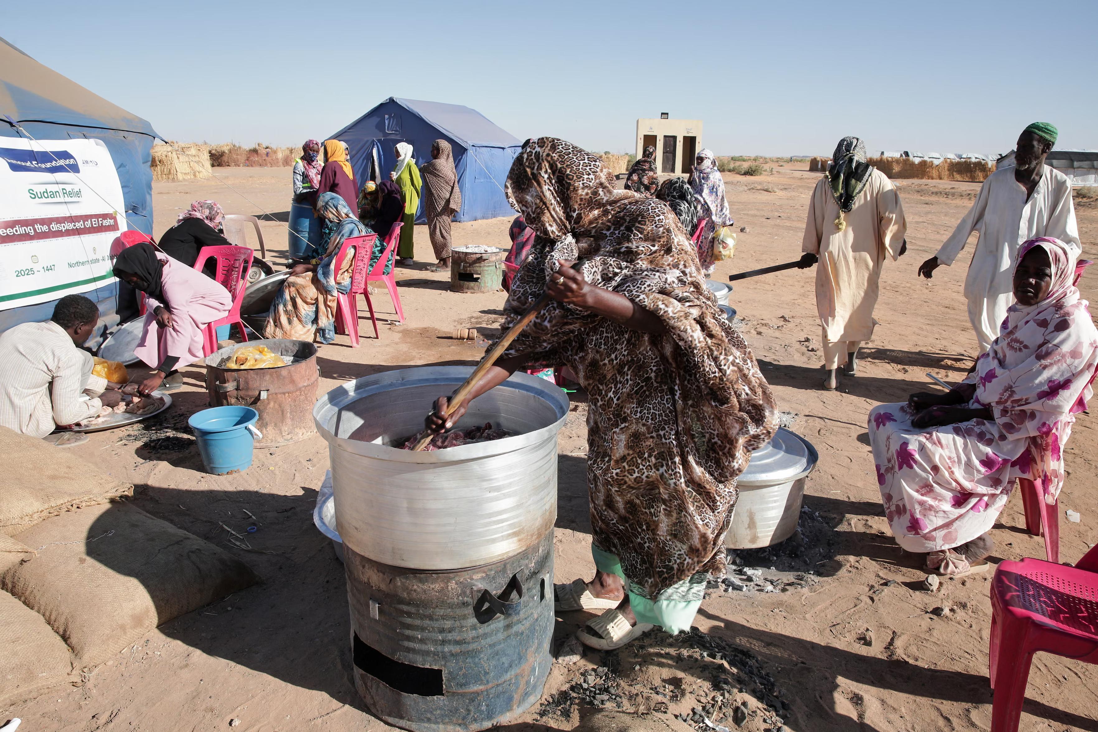 People displaced from El Fasher use a makeshift community kitchen.