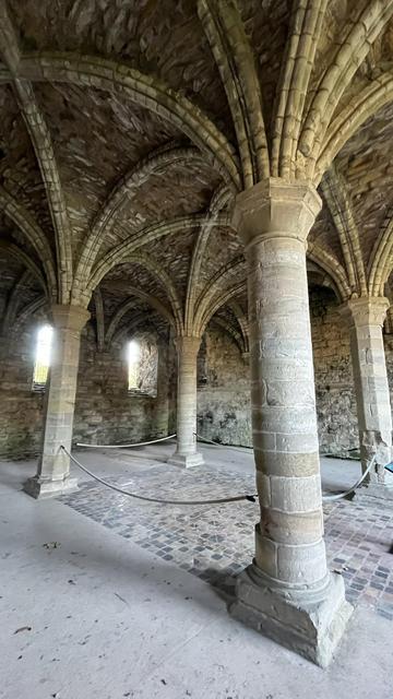 The interior of the Chapter House (some call this the East Range),  the vaulted roof is supported on four pillars and a square tiled floor is between the pillars.