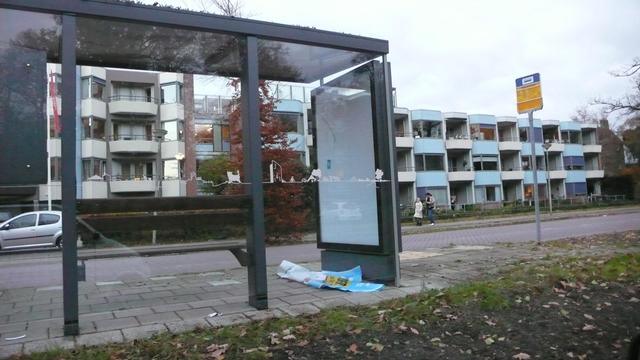 lege bushok reclame, met de poster op de grond ervoor
er in de blauwe diefstal
steek die maar in je zak sticker
en ernaast geschreven#ZapGames2025
