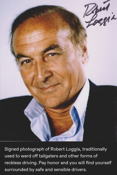 "Signed photograph of Robert Loggia, traditionally used to ward off tailgaters and other forms of reckless driving. Pay tribute and you will find yourself surrounded by safe and sensible drivers."