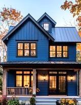 A blue to story country house with lights in all the windows 