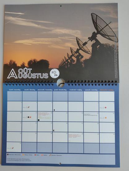 NL: Kalenderpagina van augustus 2026 met een rij satellietenantennes bij zonsondergang.