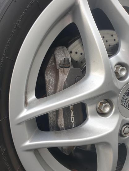 Somewhat chalky black brake caliper, the anodised finish showing its age.