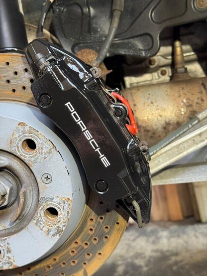 Shiny black painted brake caliper.