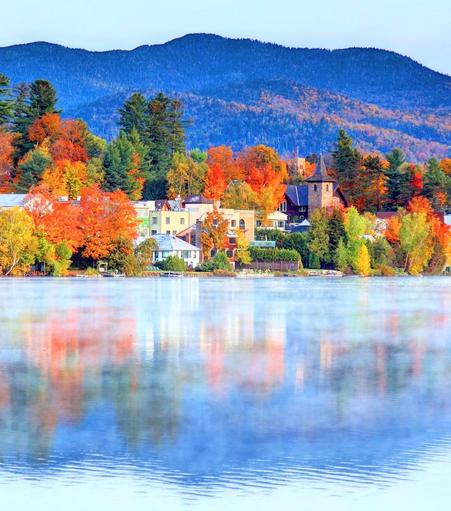A gorgeous Autumn scene of a lake and bright colorful houses *& trees on the distant shore!
