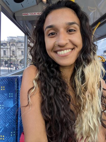 Me, a brown girl, smiling on a public bus