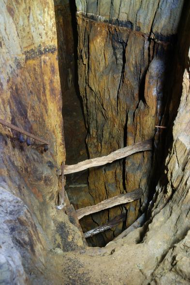 Stope workings following a vertical dip, with timbers across the opening. An old floor, worked through, is seen at top.