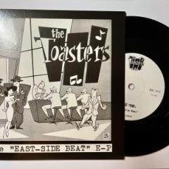 Eine illustrierte Plattenhülle für „East-Side Beat“ der Band The Toasters mit einem Schwarz-Weiß-Design, auf dem Musiker und Tänzer zu sehen sind. Neben der Hülle ist teilweise eine Vinylplatte zu erkennen.