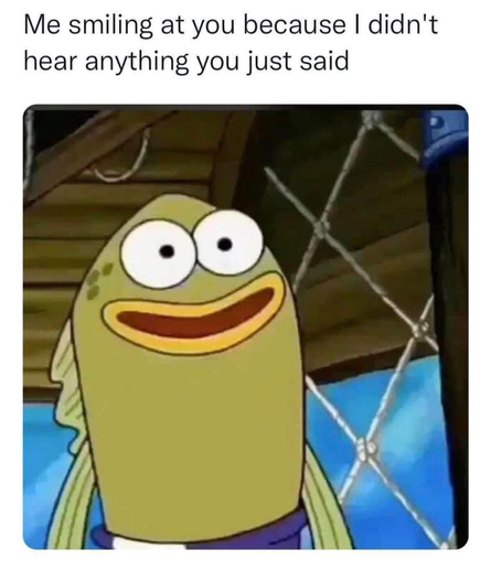 The image is a close-up shot of a cartoon character fish from the tv animation show "Spongebob" with a wide, exaggerated smile. 

The character is primarily a pale green color and has large, bulging white eyes with black pupils. It is wearing a dark purple collar. 

The background is a blurry, dark blue with several bright white, star-shaped flares. The text overlaid on the image reads: "Me smiling at you because I didn't hear."