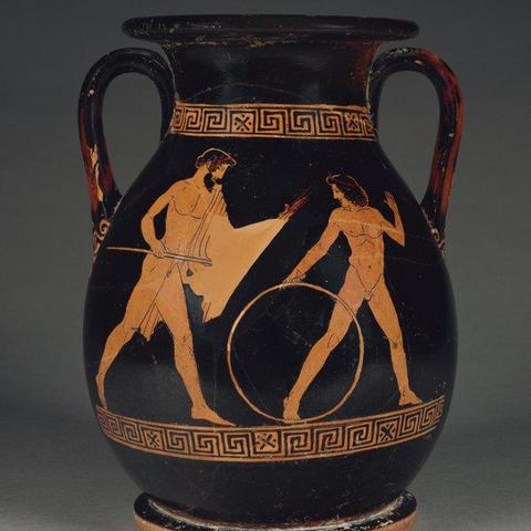 Red figure vase painting of Zeus pursuing Ganymede. Zeus is depicted as a mature, bearded man with a wreath in his hair and a himation draped over one shoulder. He holds his thunderbolt in his left and his sceptre in his right. Ganymede is turning back to look at Zeus, a large hoop in his right, his left hand raised. He is depicted as a young man with shoulder-length hair and a fillet. Both are nude.