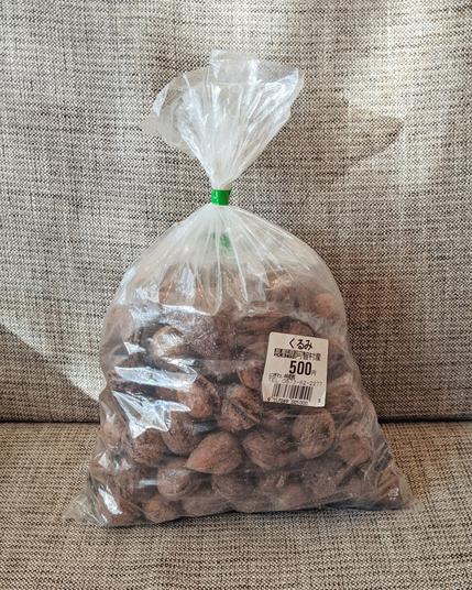 ビニール袋にたっぷり入った小ぶりの殻付きクルミの写真