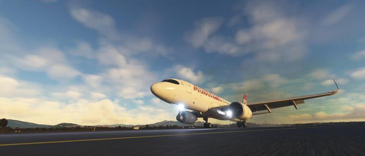 The image depicts a commercial airplane on a runway, likely in a simulation or a virtual environment. The aircraft is a twin-engine jet, with the landing gear extended, indicating it has just landed. The livery on the fuselage reads "Austrian," suggesting it belongs to the Austrian Airlines. The background features a clear blue sky with scattered clouds and a distant landscape that includes hills and possibly a body of water, giving the scene a serene and open atmosphere. The runway is marked with yellow lines, and the overall setting appears to be a modern airport. The image quality and lighting suggest it might be from a flight simulation game or a high-resolution rendering.