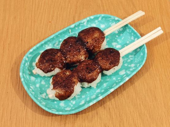 割り箸に潰した白飯を団子のように3つ串刺しにして、くるみ味噌を塗って焼いた五平餅の写真