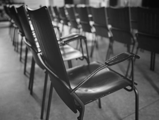 Detailaufnahme von zwei Stuhlreihen in S/W.