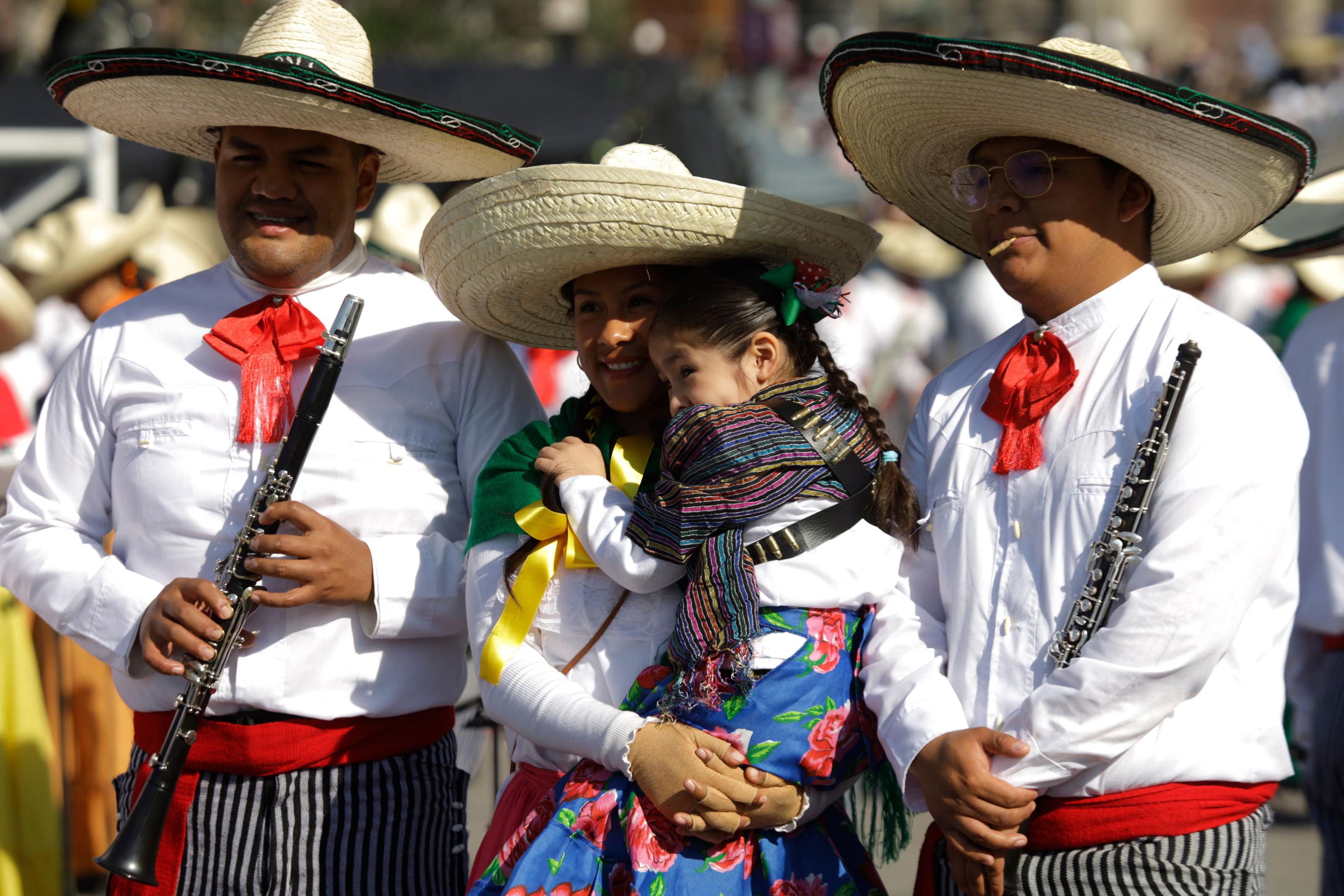 People at Zócalo Plaza take part in the Revolution Day parade.