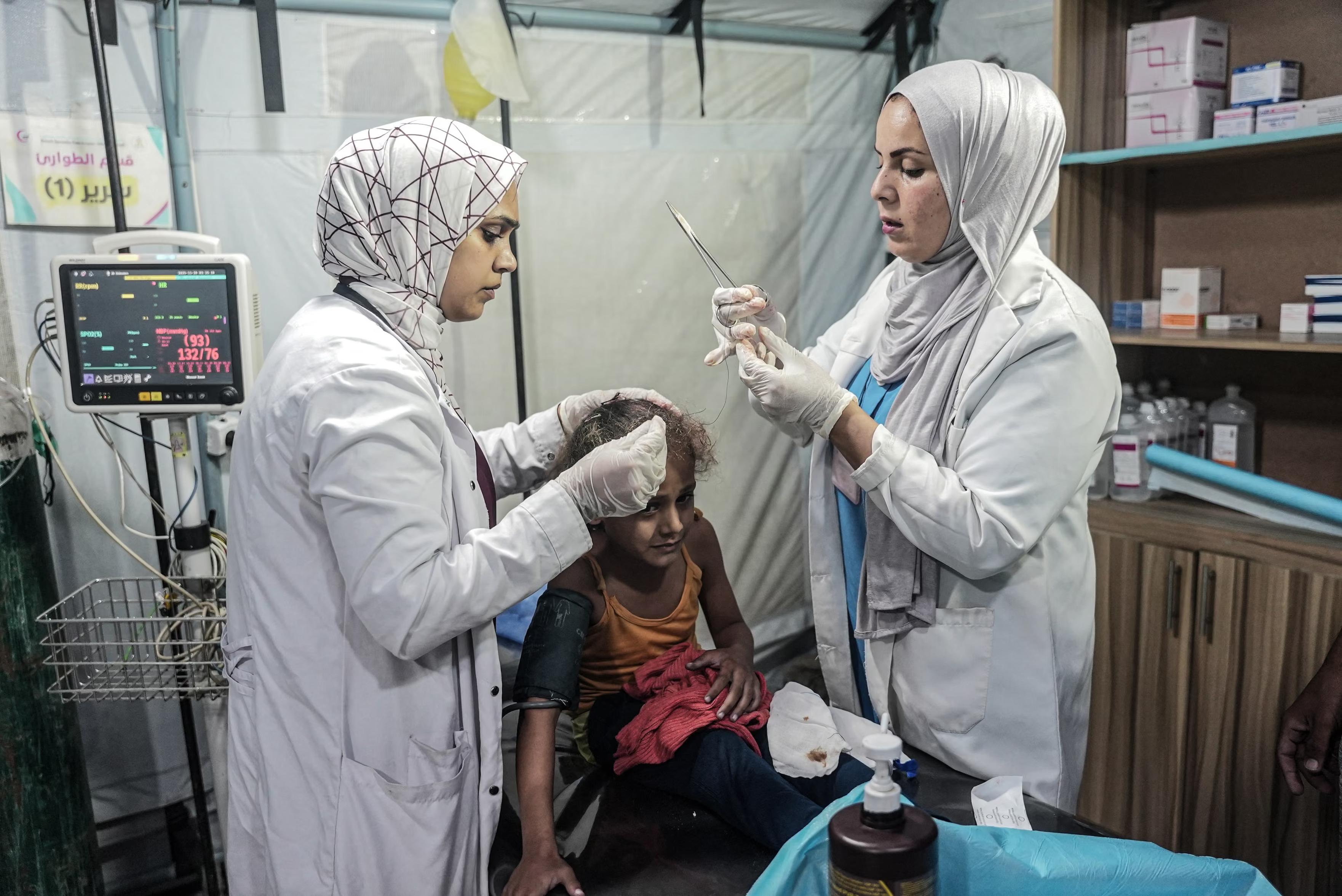 A Palestinian child injured in an Israeli attack on al-Mawasi district is treated at the Palestine-Kuwaiti field hospital.