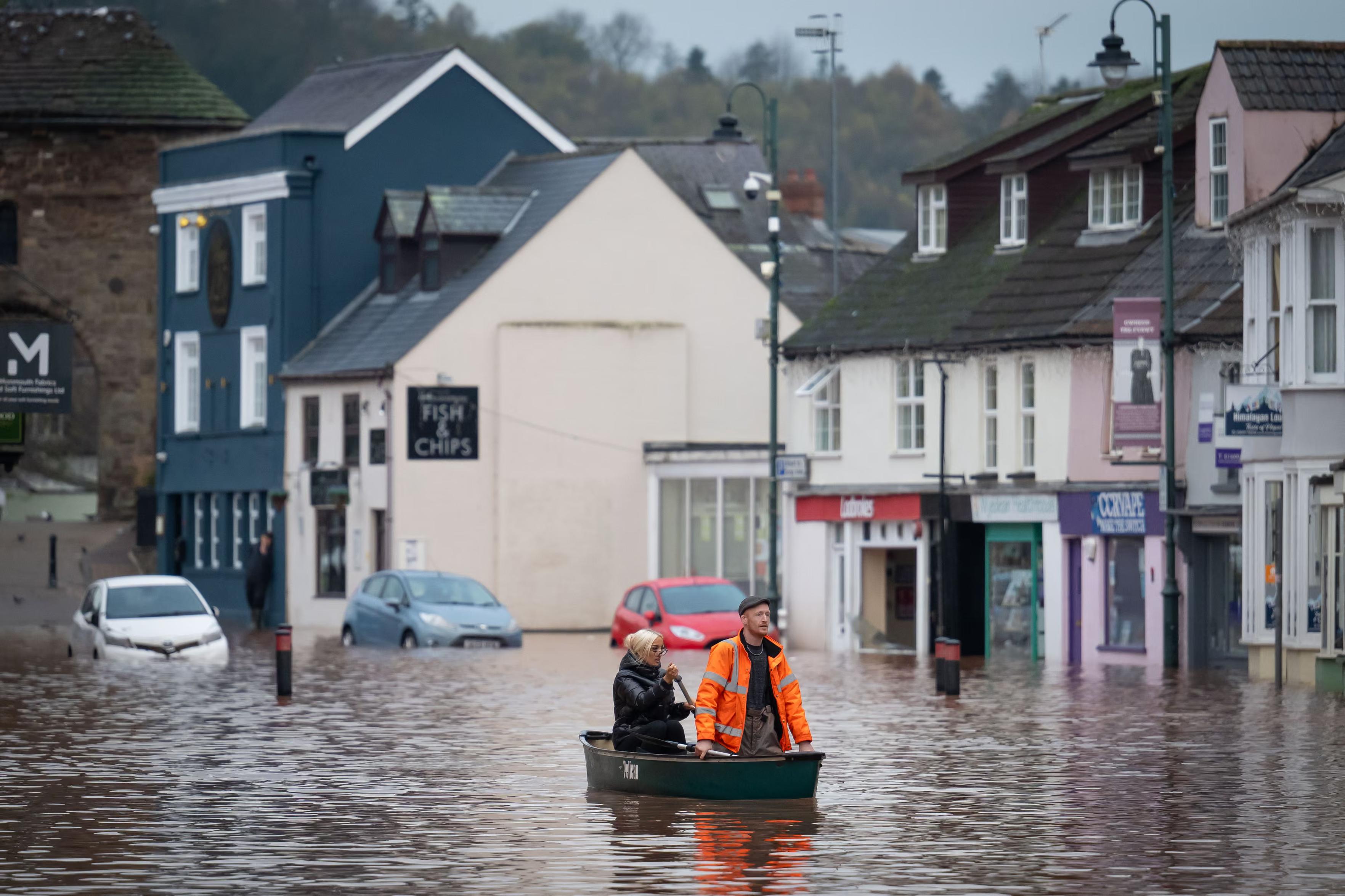 A man and woman ride in a boat on Monnow Street.