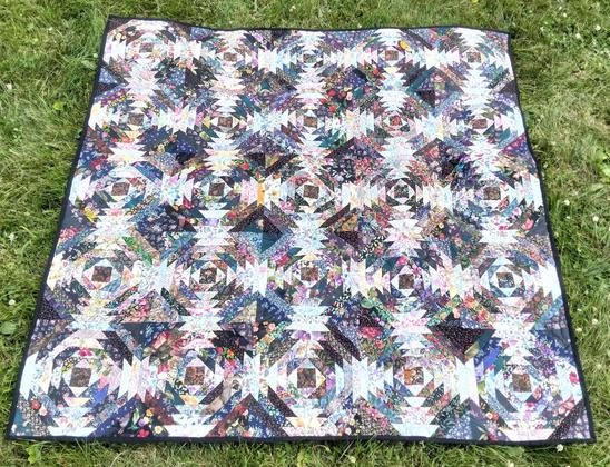a quilt, it is 25 windows with a pineapple-style design in them done in a wide variety of many different fabrics, a very complex design 