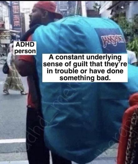 A photograph depicts the back of a person walking away from the camera on a city street. The person is wearing a bright blue hooded backpack. 

The image is overlaid with text boxes. The first text box, in the upper left corner, states "ADHD person." 

The second text box, covering the majority of the image and backpack, states "A constant underlying sense of guilt that they’re in trouble or have done something bad." 

The background shows a sidewalk and buildings, suggesting a busy urban environment.