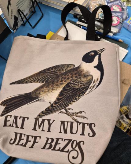 a tote bag that reads EAT MY NUTS JEFF BEZOS