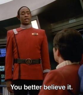A medium shot of a Star Trek-type scene: Ensign Tuvok stands and speaks to a seated figure.  Caption: "You better believe it."