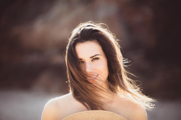 Mujer con pelo al viento y sombrero.