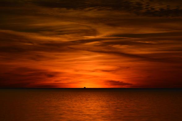 Deep orange sunset casting an orange hue across the lake