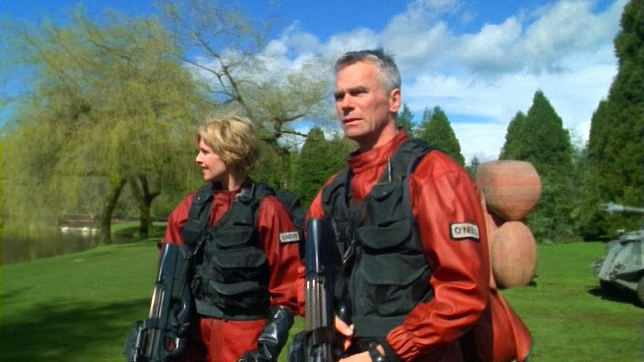 Major Carter and Colonel O’Neill standing in the garden wearing hazmat suits