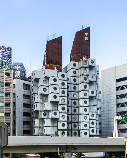Un edificio de unas 15 alturas que parece formado como por dos torres de "cubos" que tienen el aspecto de lavadoras (ya que tienen una ventana circular). Tiene dos "crestas" metálicas (aparentemente oxidadas) en las terrazas superiores.