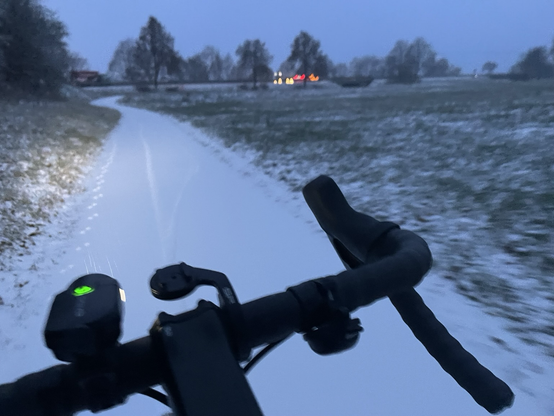 Fahrradfahren auf schneebedecktem Radweg früh zur Arbeit