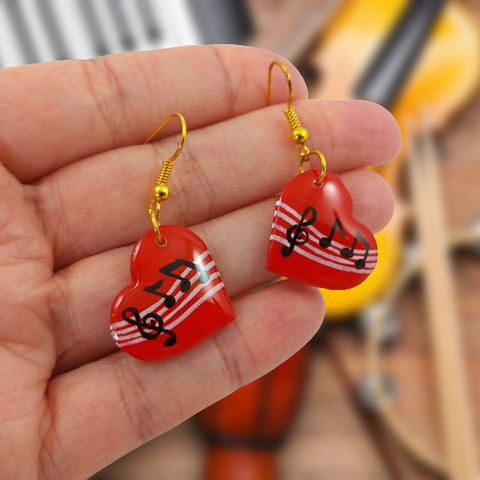 Boucles d'oreilles fantaisie pendantes éco-responsables réalisées par la créatrice Savousépate.
Les perles, en forme de coeurs rouges ornés d'une partition de musique, sont réalisées en CD recyclé, découpées et peints à la main, puis recouvertes de résine.
Les crochets sont en laiton doré, mais sont disponibles dans d'autres coloris et métaux.