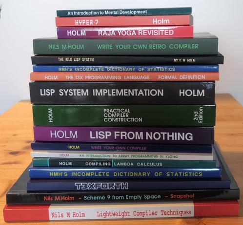 A stack of books: An Introduction to Mental Development, Hyper 7, Raja Yoga Revisited, Write You Own Retro-Compiler, The Kilo LISP System, NMH's incomplete Dictionary of Statictics, The T3X Programming Language, LISP System Implementation, Practical Compiler Construction, LISP From Nothing, Write Your Own Compiler, An Introduction To Array Programming in Klong, Compiling Lambda  Calculus, T3XFORTH, Scheme 9 from Empty Space, Lightweight Compiler Techniques