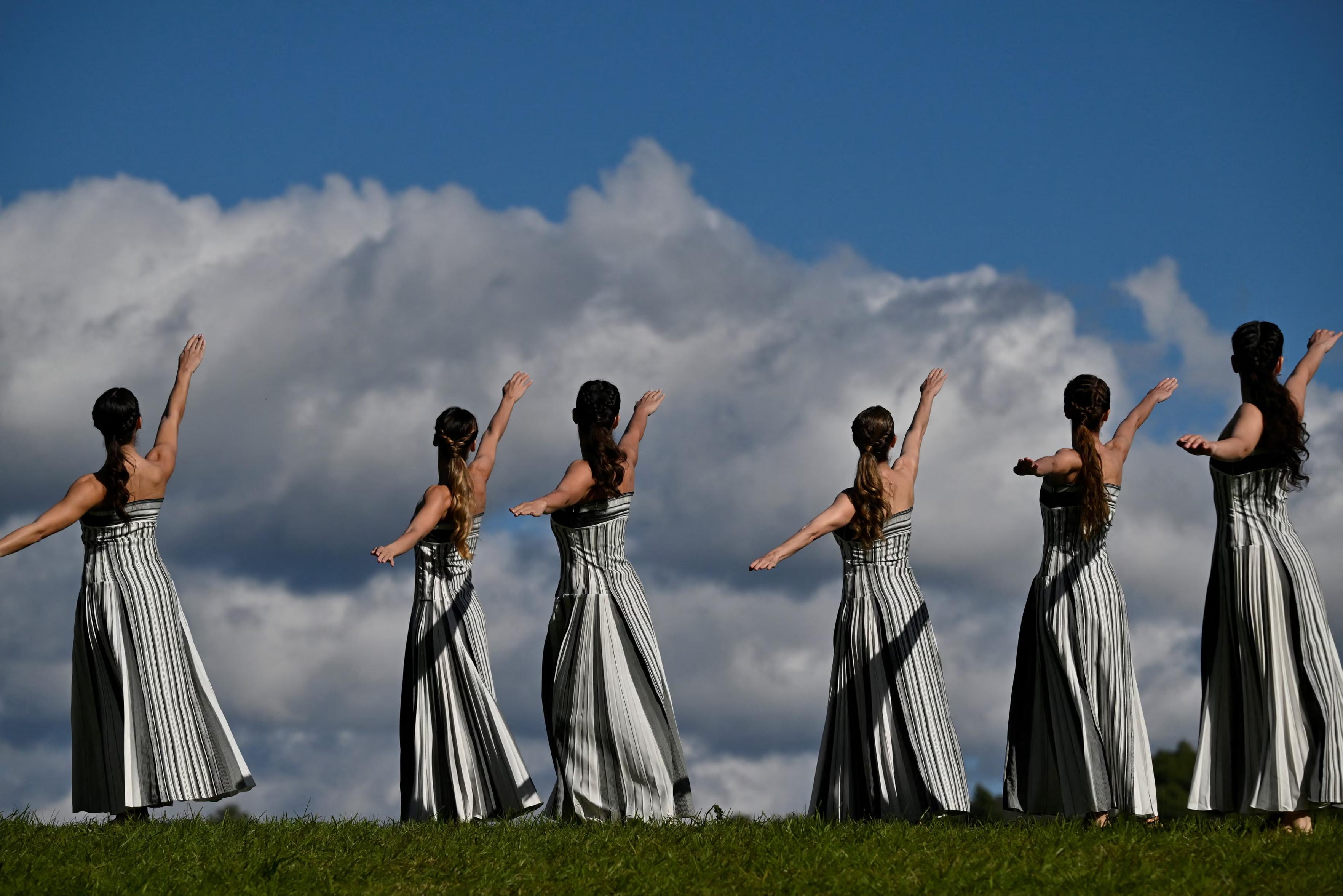 Women rehearse the lighting of the Olympic flame.