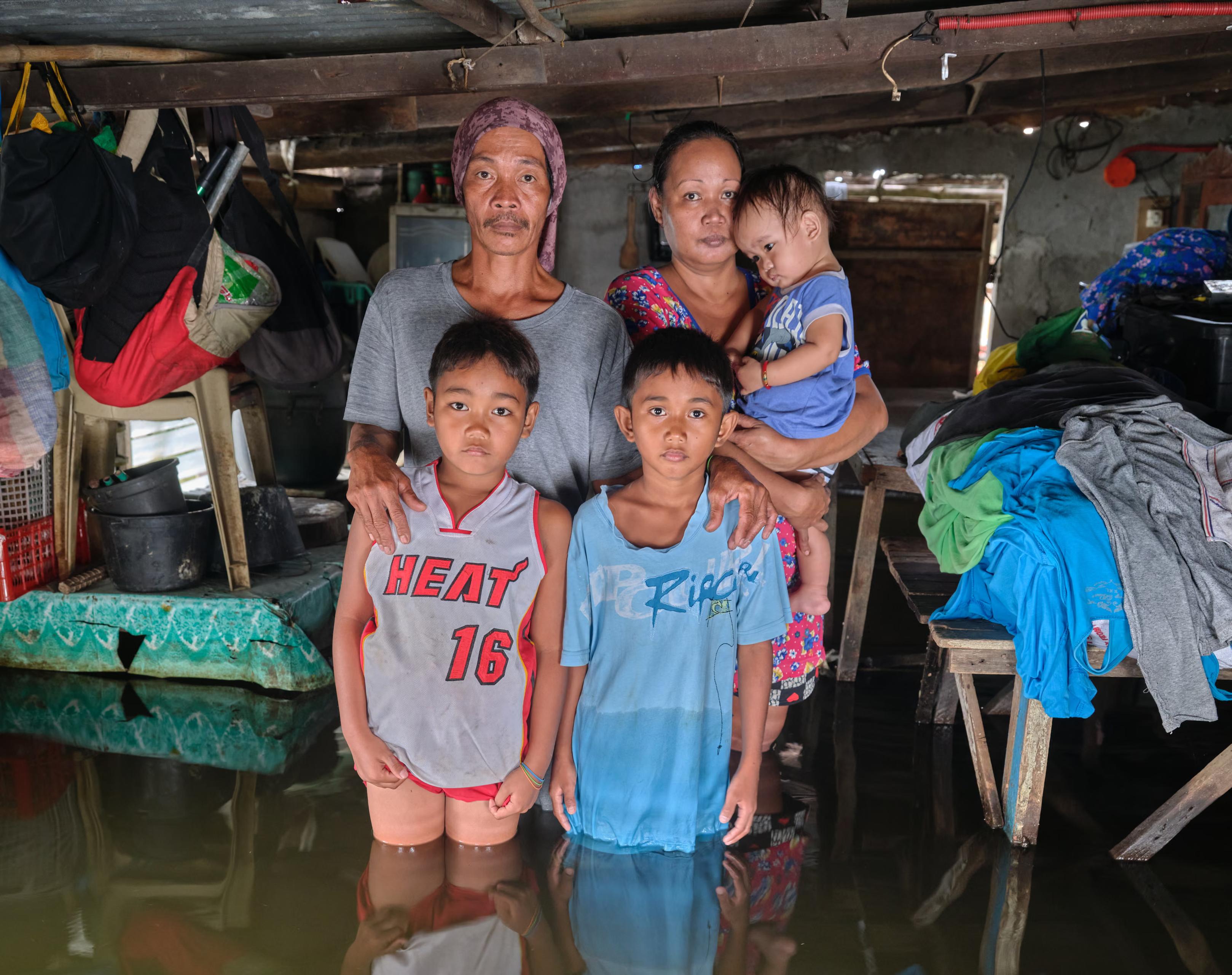 A family with three children standing inside their flooded house.
he country is one of the smallest contributors to climate change but one of the places most affected by its impacts. Gideon Mendel’s visceral portraits from his project Drowning World show people in Bulacan province dealing with the climate emergency in their daily lives.