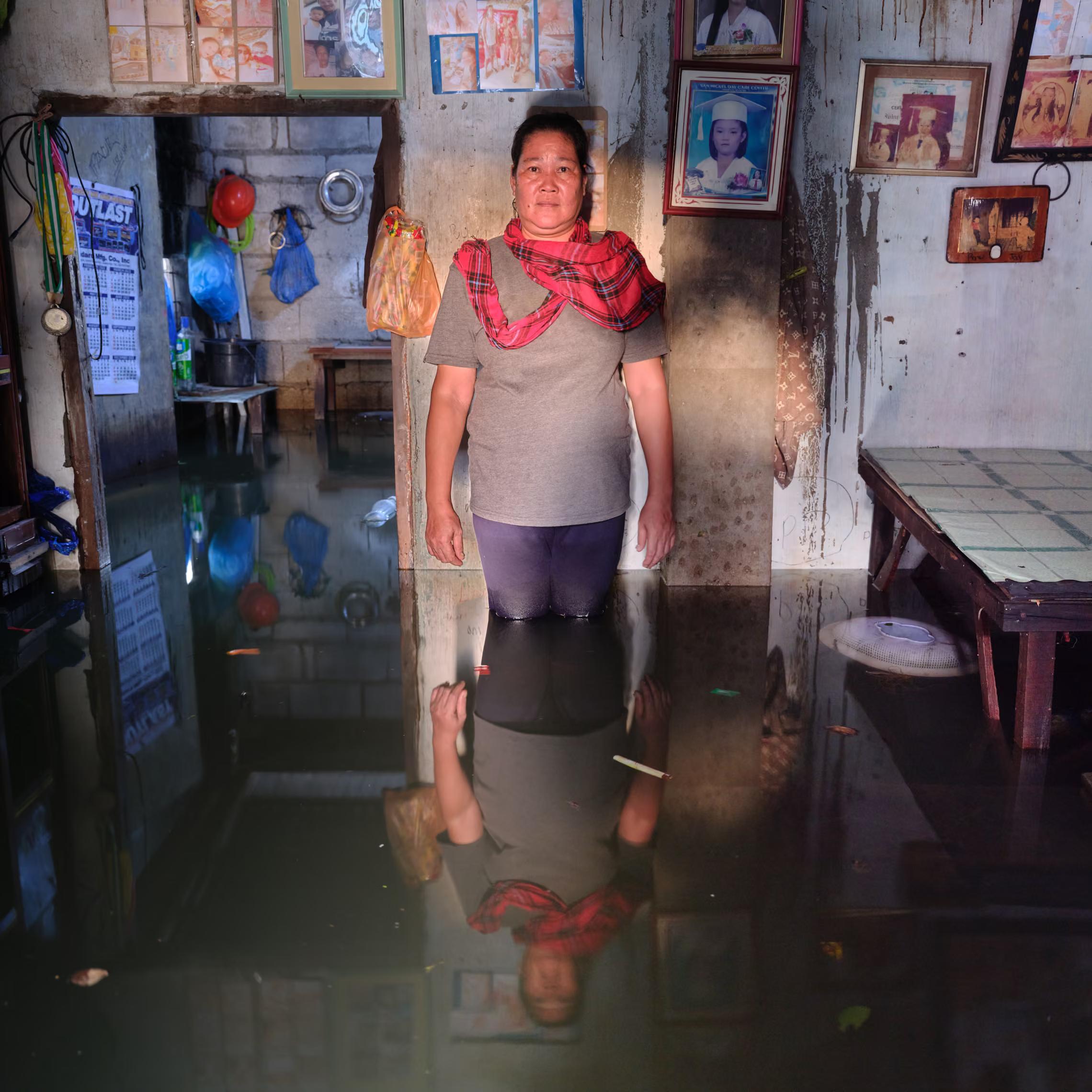 A woman stands in her flooded kitchen,
"When it’s supposed to be hot, it rains. When it’s supposed to be rainy, it becomes hot. The changes are quite obvious. I hope we find something within ourselves so this doesn’t continue."