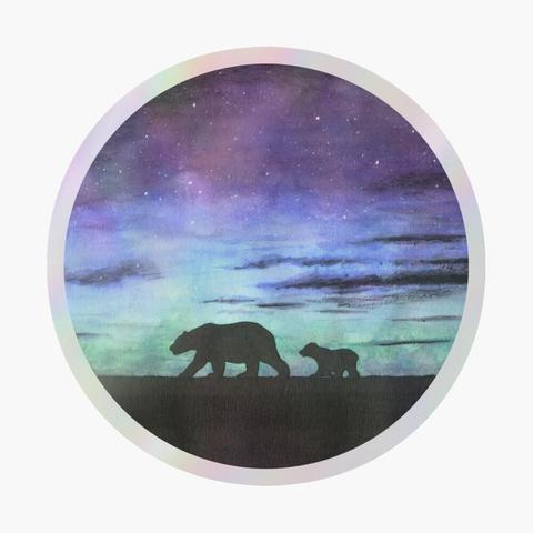 Sticker holographique rond d'une aquarelle représentant les silhouettes d'une ourse polaire et son ourson marchant sur la banquise devant un ciel étoilé et nuageux et d'une aurore boréale.