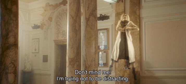 Jodie Whittaker episode. The Doctor is floating in mid-air like a spooky ghost, phasing in and out, while reaching into her jacket pocket, fiddling with something. She’s inside a big posh manor, fancy embellished walls and marble columns and everything. Caption reads, “Don’t mind me. I’m trying not to be distracting.” Not trying very hard, apparently.