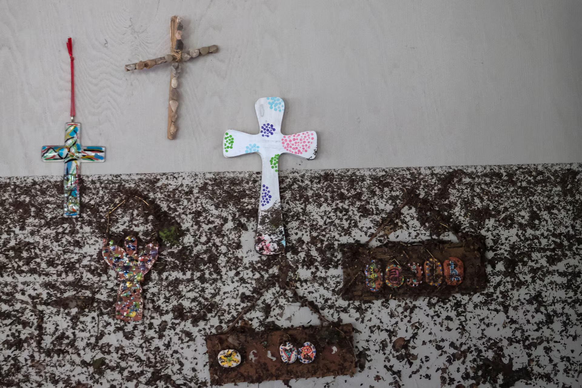 Crosses hang from a wall with marks showing the height of the waterline, following flooding on the Guadalupe River, at Camp Mystic, Hunt, Texas.