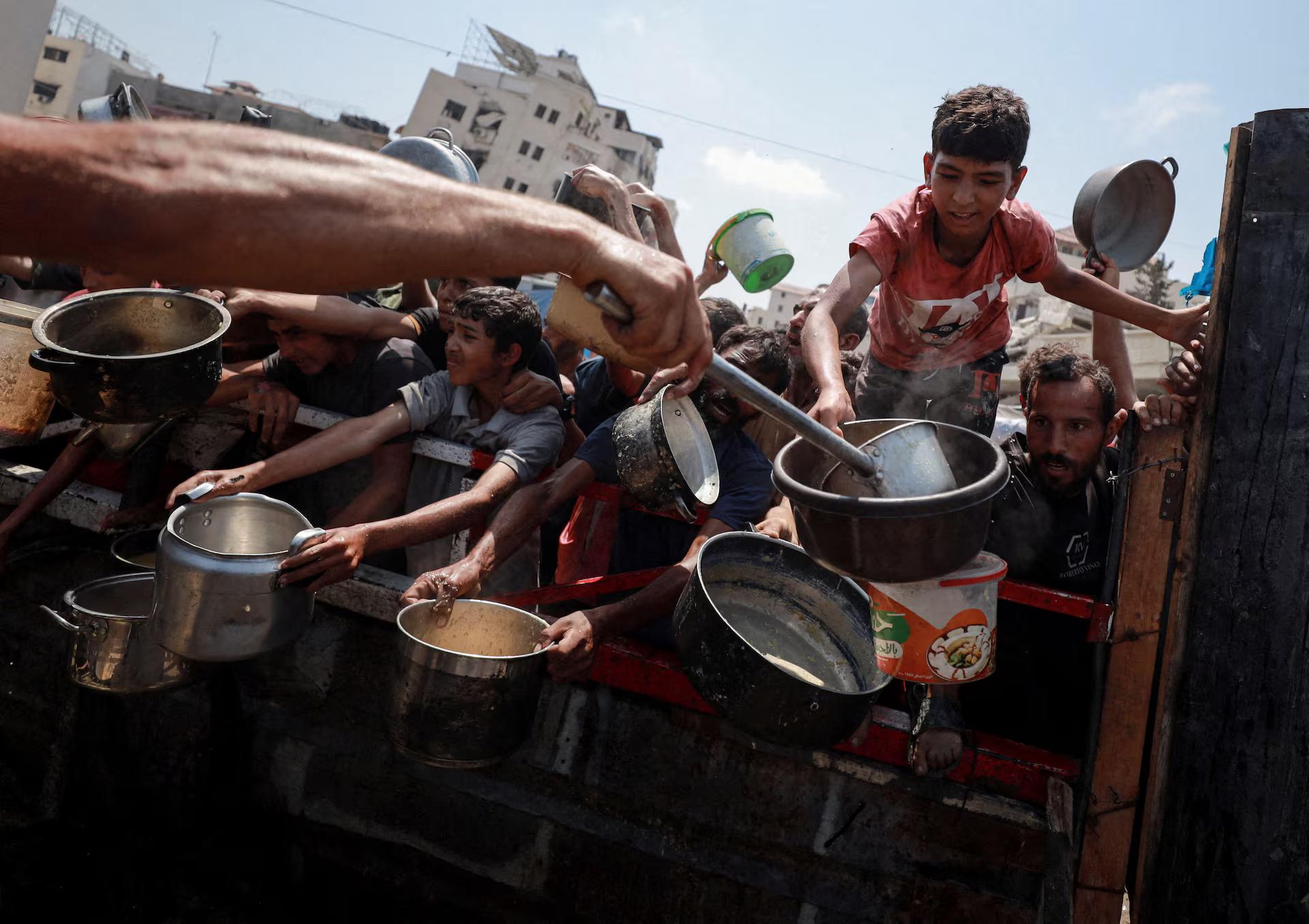 Palestinians gather to receive food from a charity kitchen.