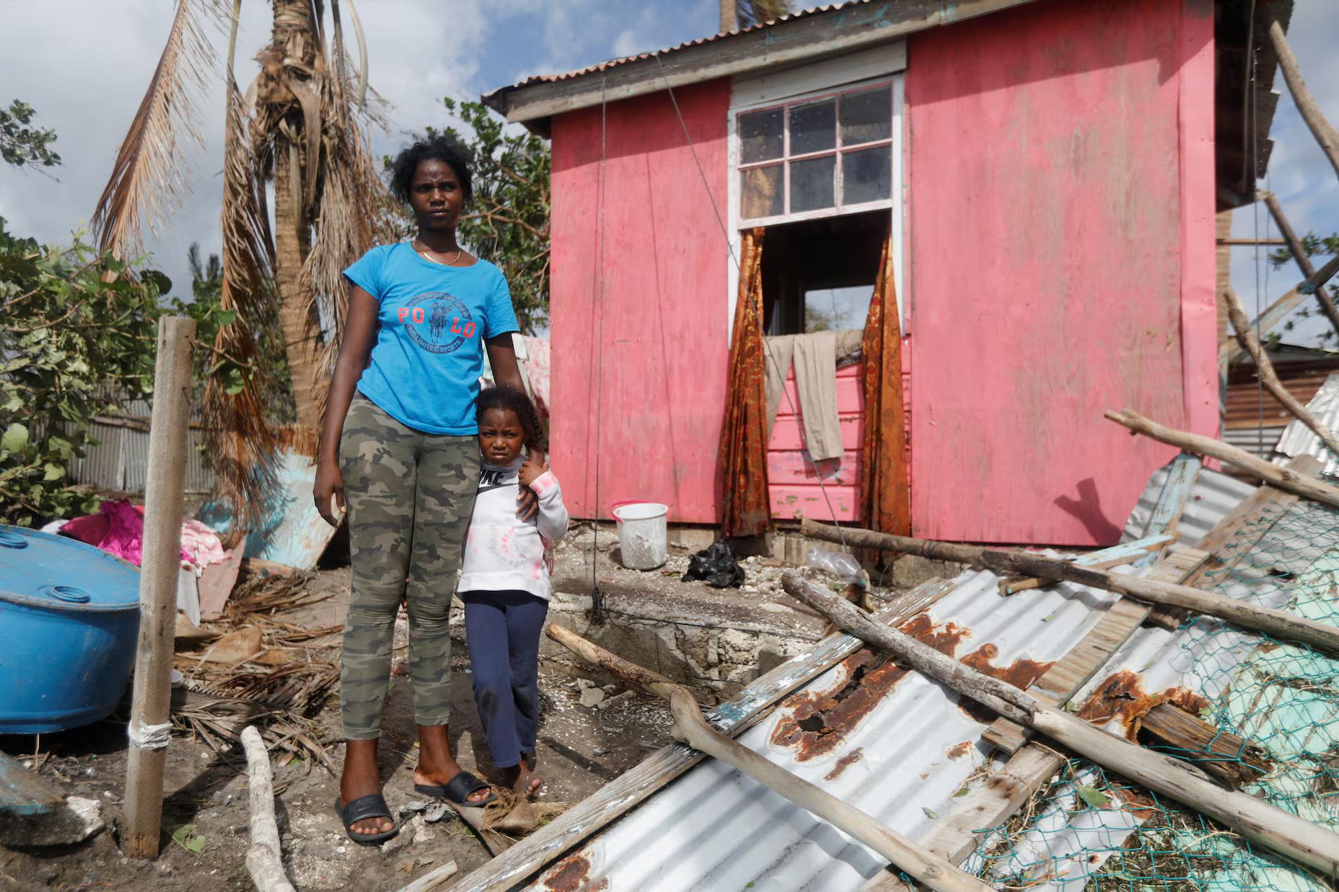 Camilla Powell 27, and daughter Destiny Ellington, 5, stand outside of their home after Hurricane Melissa made landfall, in Alligator Pond, Jamaica.