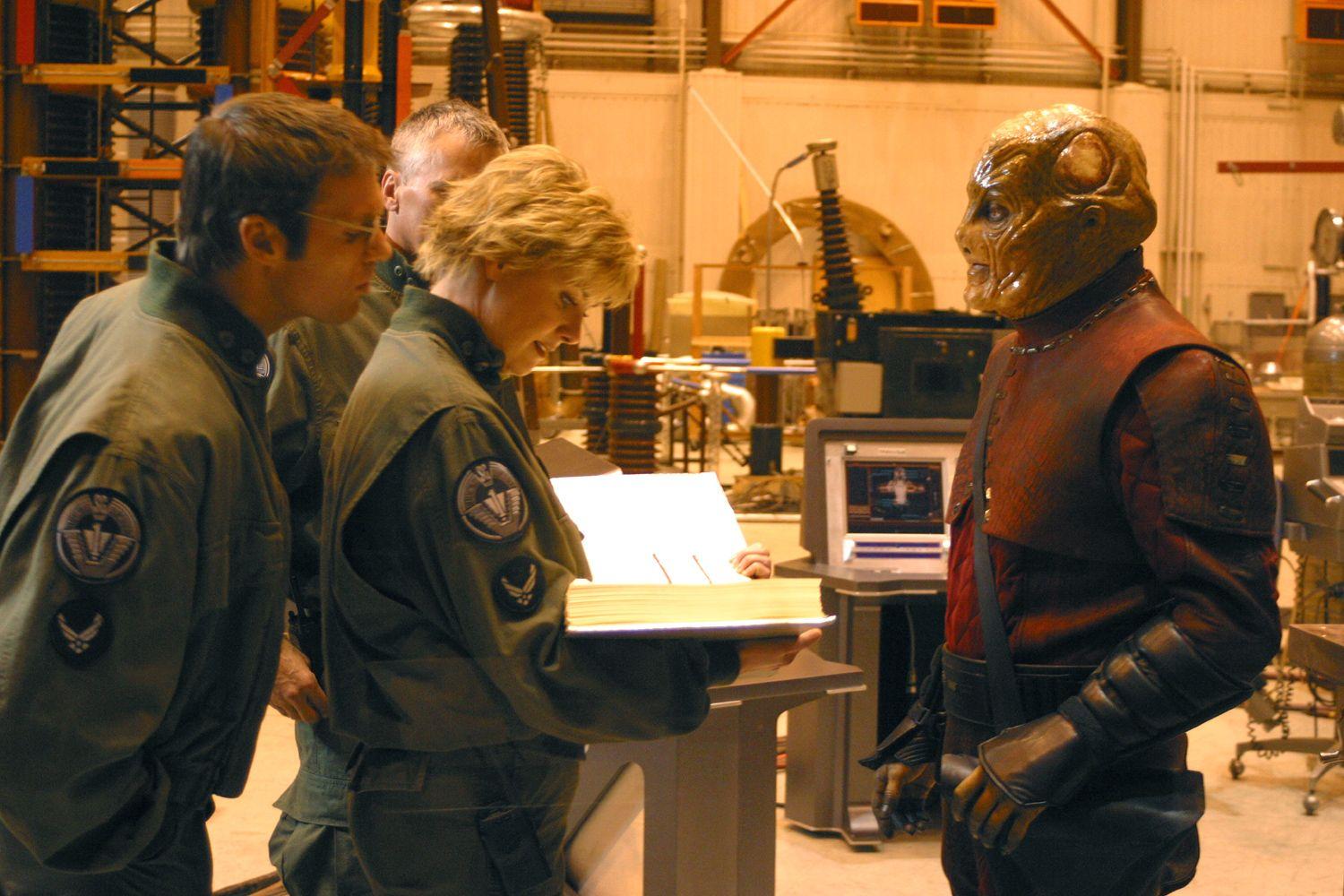 Carter and Daniel look over the giant user manual for the spaceship Carter’s about to copilot