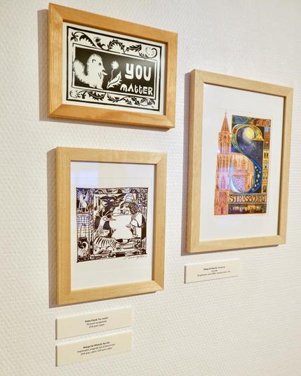 Photo of the work at the exhibition, on the bottom left, in a wooden frame. Above is a work by Daisy Gand and on the right is other work by me "Strasbourg".