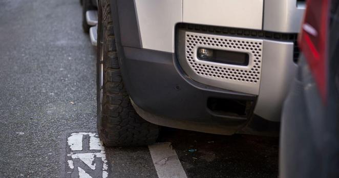 photo d'un bas de caisse et d'une roue de voiture sur un emplacement indiqué comme payant
