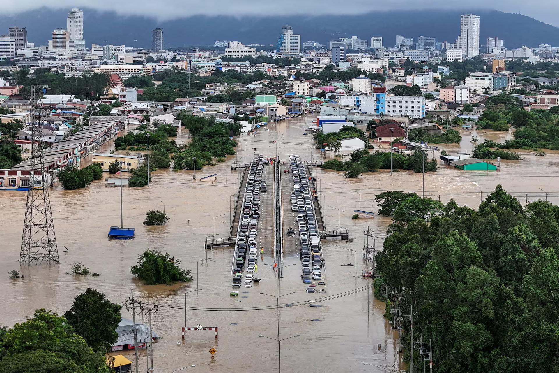 A drone view shows cars parked on a bridge to escape floodwaters in a flooded area. Some cars are flooded nevertheless.