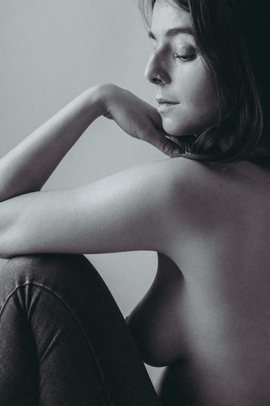 Chica morena sentada en el suelo.