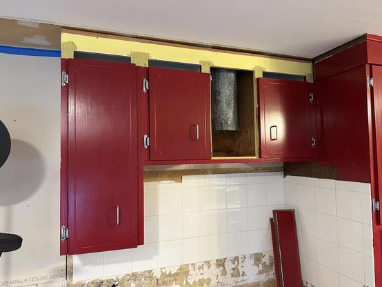Our red upper cabinets, with the vent/hood removed. A few boards of wide red moulding lean against the corner in the space where the lower cabinet once was. Notice the gap where the red MDF doors do not go all the way up, and where instead the openings were covered by the wide ceiling moulding. The ghost of owners past shrug in despondent embarrassment. The distant wail of kitties can be heard, perturbed that their favorite restaurant is being demolished before their very eyes. 