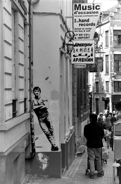 une peinture au poochoir, grandeur nature, représentant Bruce Springsteen, sur le mur d'un disquaire, noir et blanc
