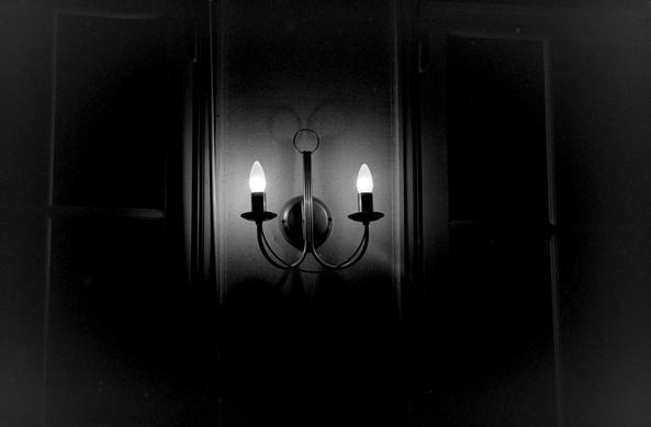 une applique en forme de chandelier,s allumée, en noir et blanc